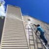 75604-employee-power-washing-siding-on-ladder