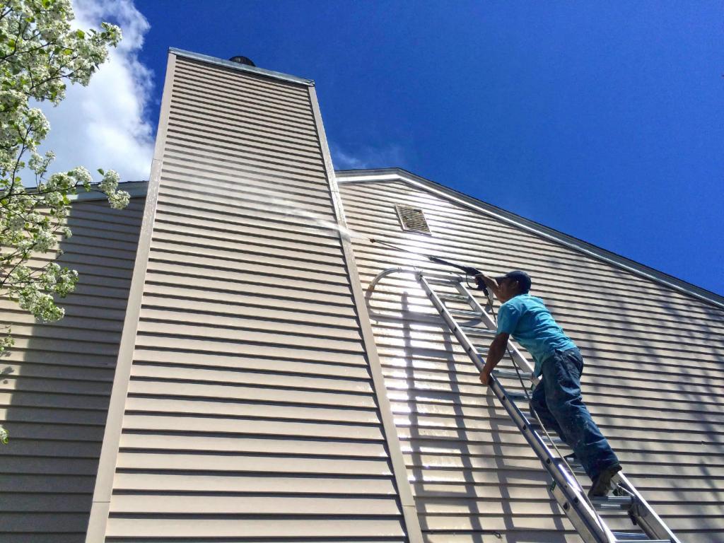 75604-employee-power-washing-siding-on-ladder